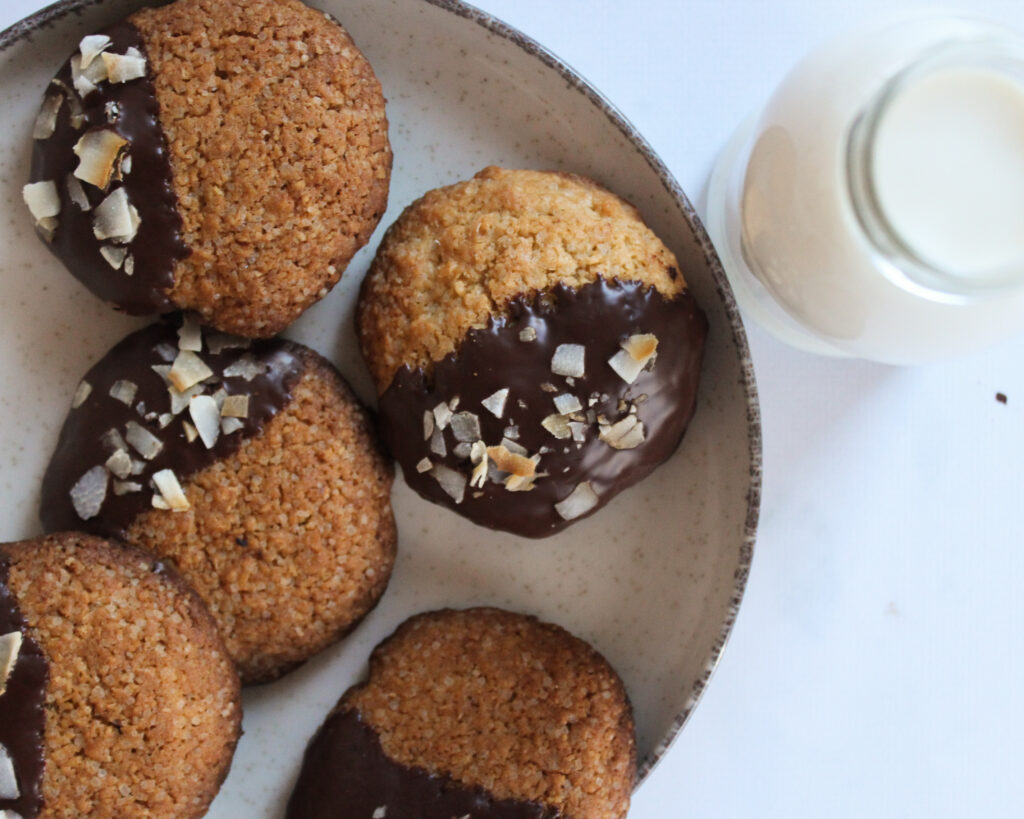 Coconut biscuits dipped in chocolate decorated with coconut shavings 